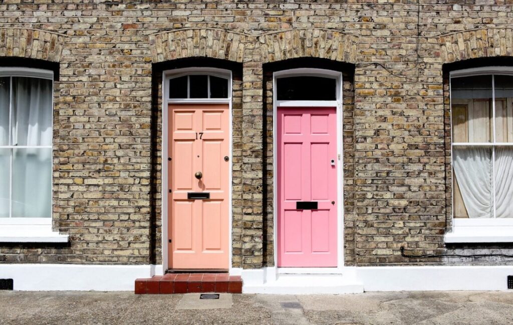 Wat is een LAT-relatie? 5 Twee naburige bakstenen rijtjeshuizen, perfect voor LAT-wonen, hebben gewelfde ramen en twee voordeuren - een perzikkleurig met het nummer 17, de andere roze - elk geaccentueerd door kraakheldere witte sierlijsten rond de deuren en ramen.